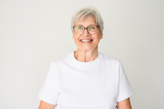 Portrait of elderly woman with eyeglasses over studio white