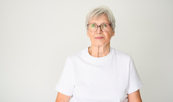 Portrait of elderly woman with eyeglasses over studio white