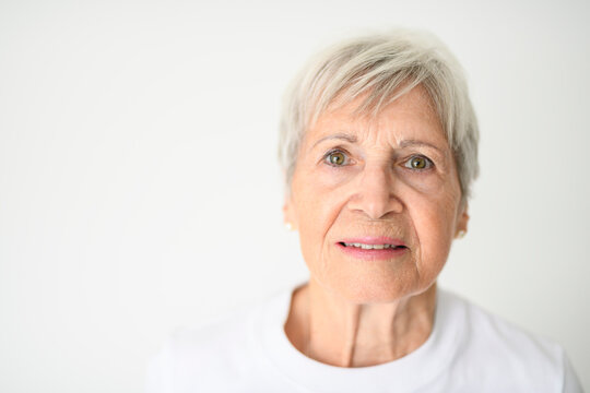 Portrait of elderly woman with eyeglasses over studio white