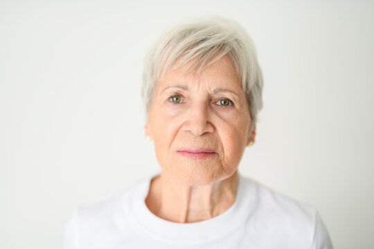 Portrait of elderly woman with eyeglasses over studio white