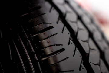 Close up texture of deep tread pattern on new black rubber tyre of agricultural machinery. © Marina