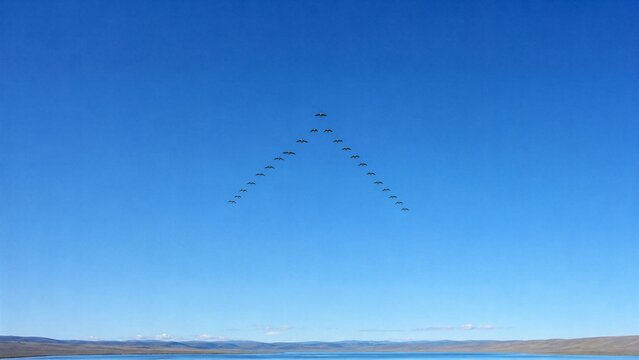 Geese Flying in V Formation: A flock of geese flies in a perfect V formation against a clear blue sky, with a serene body of water in the foreground and distant hills under a bright sun.