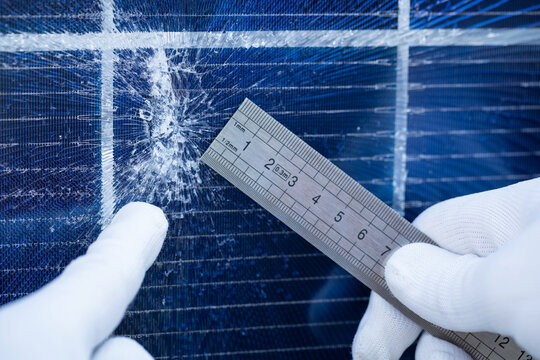 Technician Measuring Impact Damage on a Cracked Solar Panel