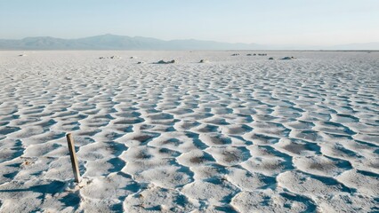 Obraz premium Expansive Salt Flats with Depths and Mountain View in Background during Daylight