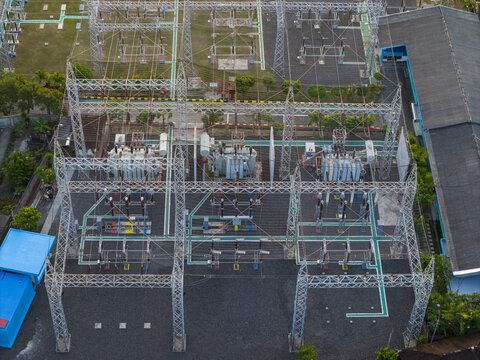 Aerial view of Nusa Dua Substation featuring electrical transformers, metal power structures, and gravel ground in Kecamatan Kuta Selatan, Bali, Indonesia.