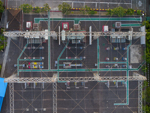 Aerial view of Nusa Dua Substation showing electrical transformers, power lines, and grid infrastructure with green pathways in Kecamatan Kuta Selatan, Bali, Indonesia.