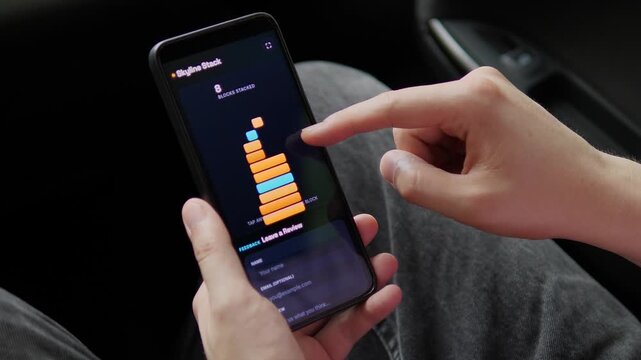 Player builds a digital block tower on a smartphone until it collapses, capturing casual mobile gaming, skill challenges and the pursuit of a higher score.