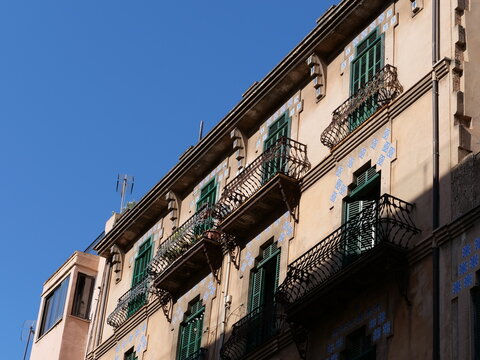 Ornate Art Nouveau Facade with Decorative Blue Tiles and Green Shutters