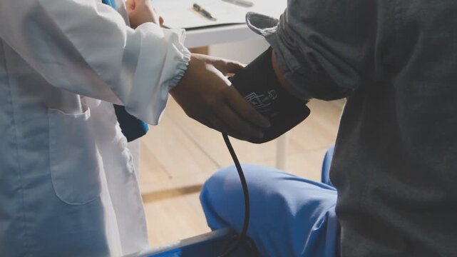 senior using a blood pressure cuff during a telemedicine consultation via digital tablet at home.
