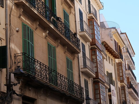 Historic Street Facades with Ornate Balconies and Enclosed Wooden Bay Windows