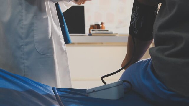 senior using a blood pressure cuff during a telemedicine consultation via digital tablet at home.