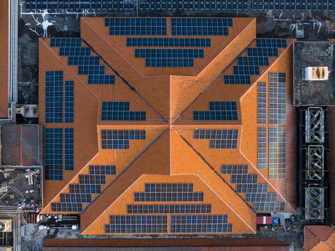 Aerial view of a large terracotta-tiled roof covered with solar panels, featuring HVAC units on the side, located in the Nusa Dua Resort Area in Kecamatan Kuta Selatan, Bali, Indonesia.