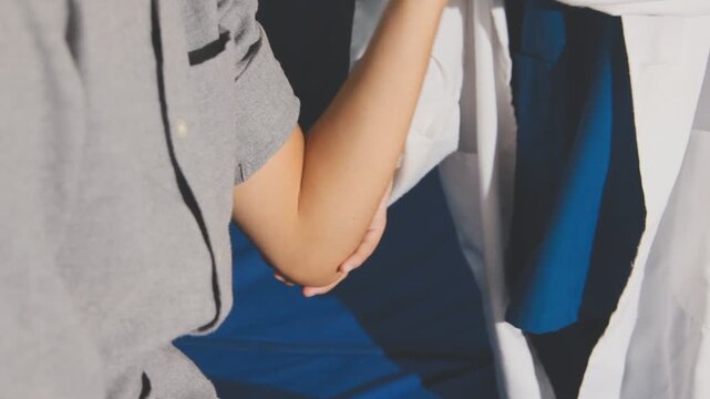Physical therapist performs shoulder range of motion test on male patient
