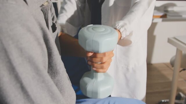 Physical therapist performs shoulder range of motion test on male patient