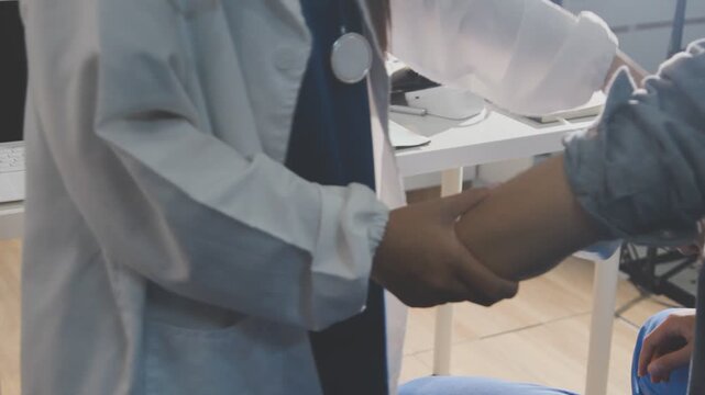 Physical therapist performs shoulder range of motion test on male patient