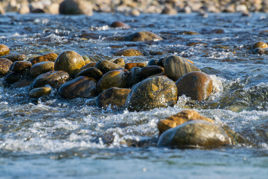 Murti river in the morning, riverbed in foreground with flowing water and stones. Scenic beauty of Dooars landscape, West Bengal, India