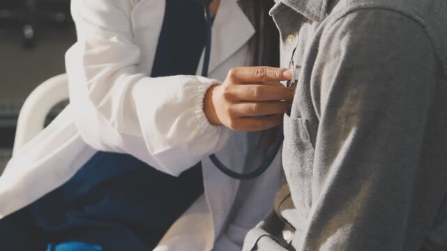 Doctor use stethoscope, checking up heart beat, auscultation in doctor office at hospital. Patient worker has to get medical checkup every year for her health or