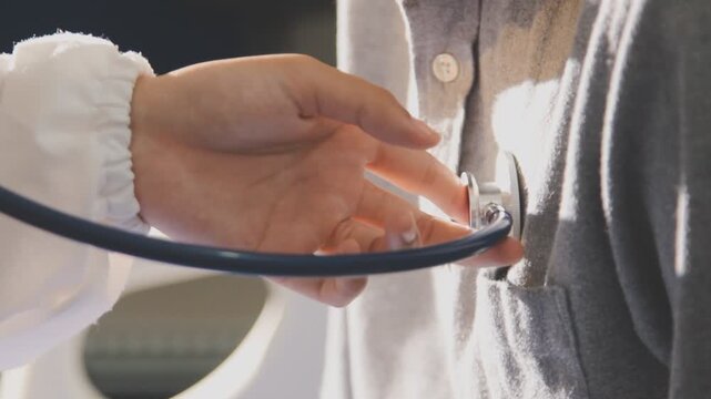 Doctor use stethoscope, checking up heart beat, auscultation in doctor office at hospital. Patient worker has to get medical checkup every year for her health or