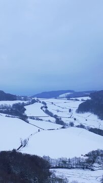 Vertical 9:16 aerial video of the snow-covered landscape in the Morvan forest region at Haut Folin, Bourgogne-Franche-Comte, France.