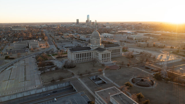 Aerial view of the Oklahoma State Capitol building surrounded by urban landscape and city skyline at sunset in Oklahoma City, Oklahoma, United States.