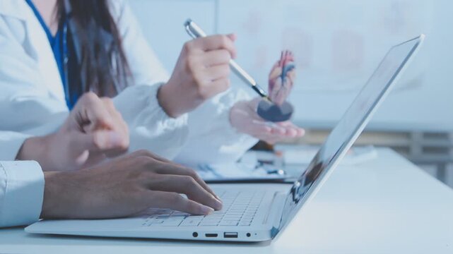 Doctor holding and pointing to an anatomical model of human lungs in a clinical office setting