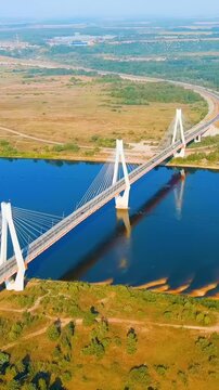 Vertical video. Murom, Russia. The Murom cable-stayed bridge, Russia's first and only three-pylon bridge, soaring across the Oka River in a sweeping Drone footage under clear summer skies. Drone foot