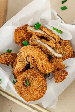 Battered and deep-fried oyster mushrooms (Pleurotus) with dipping sauce and green onion