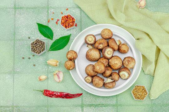 Fresh raw cremini mushrooms with spices and herbs. Healthy ingredient for cooking vegan food