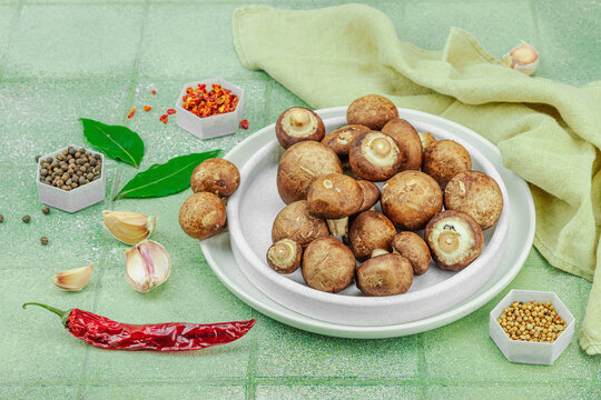 Fresh raw cremini mushrooms with spices and herbs. Healthy ingredient for cooking vegan food