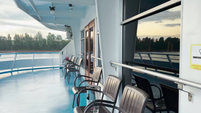 A modern cruise ship sails peacefully along the Neva River. Passengers relax on the open deck, enjoying the calm atmosphere. The serene journey brings a feeling of happy tranquility.