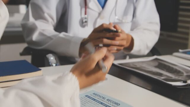 Doctor holding and pointing to an anatomical model of human lungs in a clinical office setting