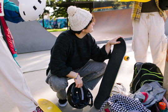 Gen-z friends prepare to skate at urban skatepark