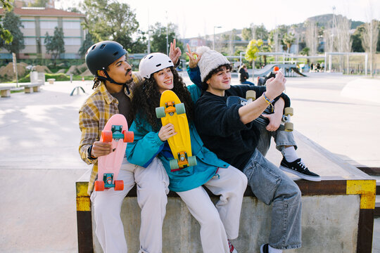 Gen Z friends take selfie with skateboard at skatepark