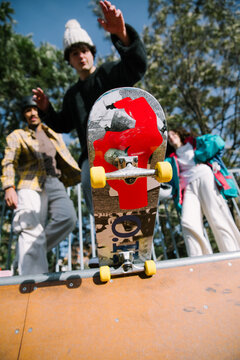 Young friends perform skateboard trick at outdoor skatepark