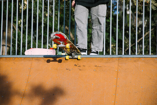 Skater perform skateboard trick at outdoor skatepark ramp