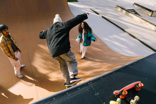 Gen Z friends skate together at an urban skatepark