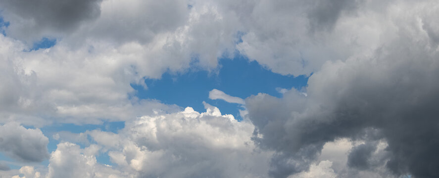 Dense white clouds with glimpse of blue sky during day
