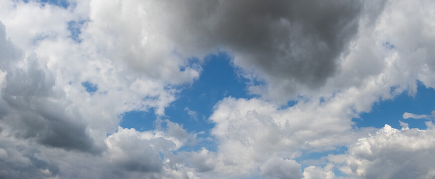Dense white clouds with glimpse of blue sky during day