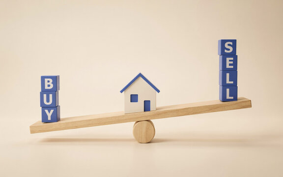 Real Estate Buy and Sell Balance Concept with House Model and Wooden Seesaw