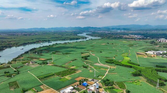 Aerial view of winding river and green farmland under blue sky