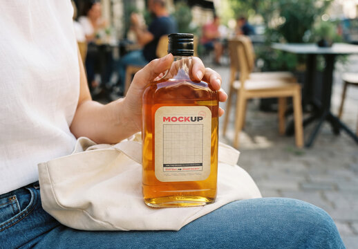 Person Holding Whiskey Bottle Flask Label Mockup