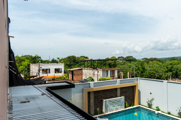 Naklejka premium Modern rooftop view with swimming pool and surrounding greenery