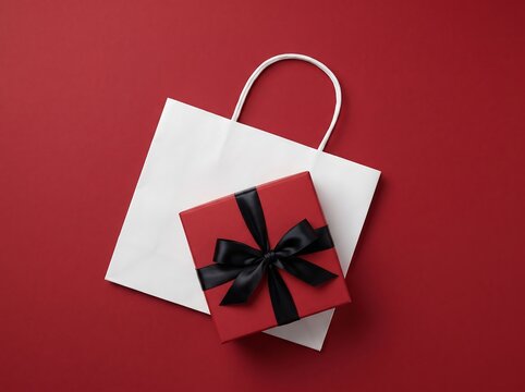 red gift box with black ribbon on white shopping bag