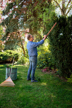 Full length of a senior mand gardening in a back yard