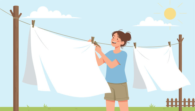 Happy young woman hanging clean white bedsheets to dry on a laundry clothesline in a sunny outdoor garden setting.