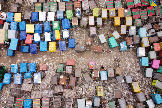 Aerial view of the Van Stand featuring numerous colorful carts arranged in rows on a dusty ground with people walking between them in Narayanganj, Dhaka, Bangladesh.