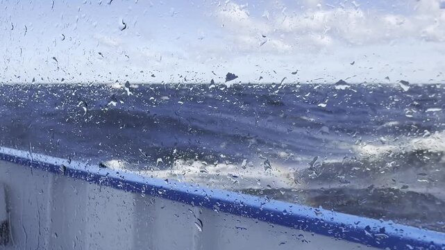 A severe storm seen through a cruise ship porthole on Lake Onega, with waves crashing against the ship's side and window, illuminated by a rainbow.