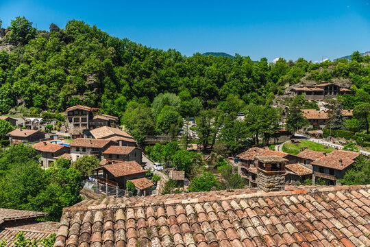 Panoramic rooftop view of Rupit medieval village surrounded by green forests in Catalonia, Spain, scenic rural landscape