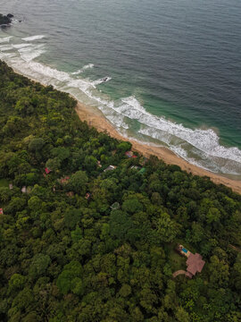 Aerial view of the lush tropical forest and coastline of Bastimentos Island with waves crashing on the sandy beach in Bastimentos Island, Bocas del Toro, Panama.