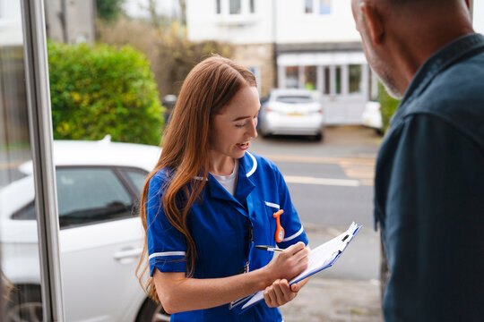 Nurse visits a home and takes notes while speaking to a patient outside